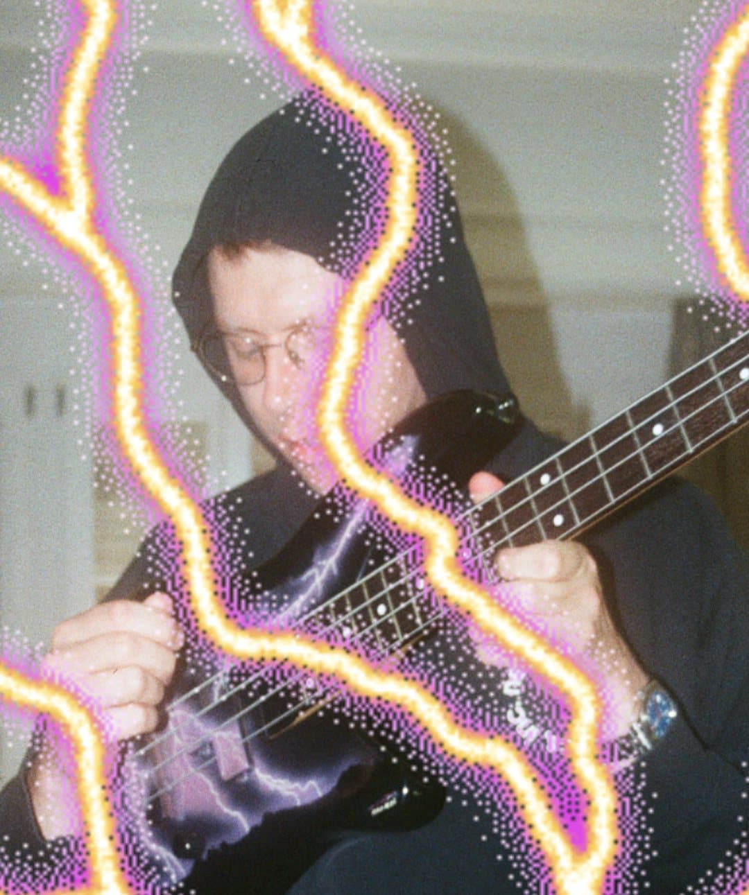 Carlo Onda in a dark hood playing bass, with neon lightning drawn over the photo